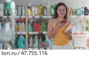 Girl buyer scans qr code on sunblock cream label. Стоковое видео, видеограф Яков Филимонов / Фотобанк Лори