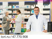 At pharmacy, man apothecary waiting for clients and invites with gesture go to chemist shop. Стоковое фото, фотограф Яков Филимонов / Фотобанк Лори