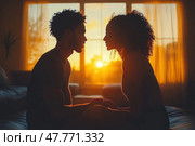 A romantic silhouette of a couple in love sitting opposite each other by a window against a golden sunset. Soft light filters through the curtains, creating a warm atmosphere of coziness, love and intimacy. The man and woman hold hands, looking into each other's eyes, which emphasizes the sincere emotional connection. The scene is filled with peace and harmony, ideal for the themes of relationships, love, family life, intimacy and trust. Стоковое AI-изображение, AI-художник Анна Кривицкая / Фотобанк Лори
