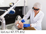 Focused cosmetologist performing laser resurfacing to senior woman. Стоковое фото, фотограф Яков Филимонов / Фотобанк Лори