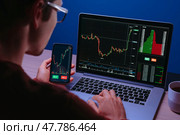 Crypto trader analyzing live cryptocurrency and stock charts on smartphone. Стоковое фото, фотограф Arsenii Palivoda / Фотобанк Лори