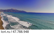 Turquoise waves lapping pristine sandy coastline, mountain silhouette framing tranquil mediterranean seascape with luminous color palette. Стоковое видео, видеограф ILIA GOROKHOV / Фотобанк Лори