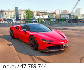 Red Ferrari SF90 Stradale parked on the street in Moscow. Supercar in urban landscape. Редакционное фото, фотограф Константин Григорьев / Фотобанк Лори