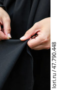 Woman's Hands Sewing a Black Banner for Ashura, Fingers Trembling; a Scene of Craft and Community Spirit. Стоковое AI-изображение, AI-художник Sergey Grishin / Фотобанк Лори