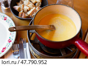 French variation of fondue, Fondue Savoyarde, preparing on table. Стоковое фото, фотограф Яков Филимонов / Фотобанк Лори