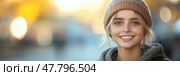 A young woman with a bright smile dons a snug beanie, enjoying the outdoor atmosphere during the enchanting golden hour. Стоковое AI-изображение, AI-художник Данила Большаков / Фотобанк Лори
