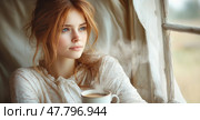 The young woman holds a steaming cup of coffee, gazing dreamily out the window with a serene expression as morning light filters in. Стоковое AI-изображение, AI-художник Данила Большаков / Фотобанк Лори