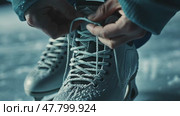 Hands tying ice skate laces on frosty surface in winter preparation sequence. Стоковое AI-видео, аниматор Sabyna75 / Фотобанк Лори