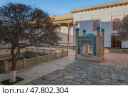 View of the courtyard of the Bahauddin Naqshbandi Memorial Complex with a pond and a chartak in the foreground on a sunny day, Bukhara, Uzbekistan. Стоковое фото, фотограф Ula Ulachka / Фотобанк Лори