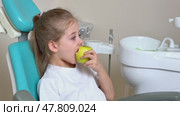 Little girl are eating green apple in the dentist's chair. Healthy teeth concept. Child eat a green apple. Slow motion footage. Стоковое видео, видеограф Ирина Михайличенко / Фотобанк Лори