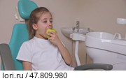 Little girl are eating green apple in the dentist's chair. Healthy teeth concept. Child eat a green apple. Slow motion footage. Стоковое видео, видеограф Ирина Михайличенко / Фотобанк Лори