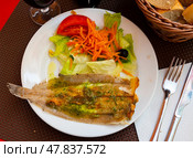 There is plate with fried solea flatfish and salad of fresh veg on wooden table. Стоковое фото, фотограф Яков Филимонов / Фотобанк Лори