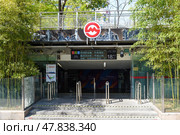 Shanghai, China - 1 April 2025: The entrance to People's Square Station (Exit 18) with bamboo groves in spring foliage. Sunny daylight highlights the contrast between urban infrastructure and natural elements. Редакционное фото, фотограф Татьяна Терехина / Фотобанк Лори