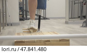 A woman with a modern robotic prosthetic leg is working out in the gym. Стоковое видео, видеограф Андрей Шалари / Фотобанк Лори