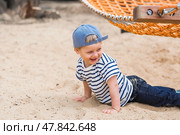 Summer lifestyle. A cute little boy is having fun playing in a hammock on the beach on a modern playground. The concept of family entertainment and leisure. Стоковое фото, фотограф Photojuli / Фотобанк Лори