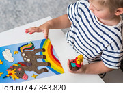A little boy is playing with plasticine. Fine motor skills-developing games for children. The kid makes a horse. Useful games for child development. Стоковое фото, фотограф Photojuli / Фотобанк Лори