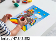 A little boy is playing with plasticine. Fine motor skills-developing games for children. The kid makes a horse. Useful games for child development. Стоковое фото, фотограф Photojuli / Фотобанк Лори