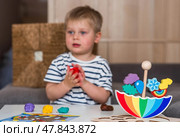 Balancing toys. A little boy is playing educational games. Children's wooden umbrella toy, colored pyramid and logic toys for children. Montessori games for child development. Стоковое фото, фотограф Photojuli / Фотобанк Лори
