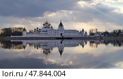 Early spring in Russia. Holy Trinity Ipatievsky Monastery, sun rays and clouds reflected in the water surface of the river. White stone temples with golden domes. Kostroma city. Стоковое фото, фотограф Ирина / Фотобанк Лори