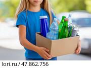 A Girl in plain colors T-shirt carries a box of recyclables. Стоковое AI-изображение, AI-художник Ирина Ручушкина / Фотобанк Лори
