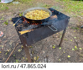 Pot of food is cooking on a fire. Стоковое фото, фотограф Олег Спиридонов / Фотобанк Лори