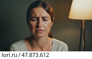 Sad depressed woman at home sitting on the couch, looking down and touching her forehead, loneliness and pain concept. Стоковое AI-видео, аниматор ALLA YURTAYEVA / Фотобанк Лори
