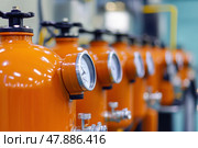 Bundle of gas cylinder and high pressure gauges, meter, valve. Orange gas tanks. Many argon cylinders with compressed oxygen for industry, welding. Fuel manufacturing. Liquefied gas production factory. Стоковое AI-изображение, AI-художник Марина Демидюк / Фотобанк Лори