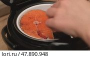 Fish is arranged in the steaming basket of a multicooker, ready for cooking. Initial stage of preparing a healthy steamed fish dish using convenient kitchen tools. Стоковое видео, видеограф Андрей Журавлев / Фотобанк Лори