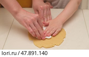 Child hands cutting cookie dough with plastic cutter on white table. Close-up baking and cooking concept. Family cooking and homemade bakery. Kid aged three years (3 year old boy) Стоковое видео, видеограф Андрей Журавлев / Фотобанк Лори