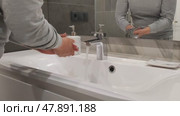 Female hands over sink in close-up. Hand washing before and after using toilet. Woman uses liquid soap to wash her hands with running tap water. Reflection in mirror. Стоковое видео, видеограф Ирина / Фотобанк Лори