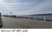 Volga river embankment in big city. People strolling along shore and enjoying sunny spring day. Well-maintained embankment with beautiful lanterns. Kostroma, Russia, April 17, 2025. Редакционное видео, видеограф Ирина / Фотобанк Лори