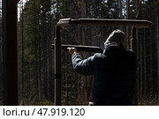 Стендовая стрельба. Мужчина с ружьем стреляет по тарелкам. Редакционное фото, фотограф Дарджания Зураб / Фотобанк Лори
