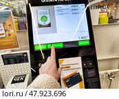 Kirov, Russia - March 27, 2025: Self-service payment kiosk allows customers to finalize grocery transactions efficiently in a busy market setting. Редакционное фото, фотограф Кривошеина Елена Леонидовна / Фотобанк Лори