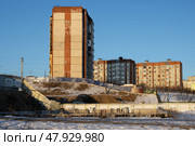Зимний городской пейзаж. Вид на многоэтажные панельные жилые дома. На переднем плане строительная площадка, огороженная забором (начало строительства новой гостиницы в Магадане). Город Магадан, Магаданская область, Дальний Восток России. Редакционное фото, фотограф Андрей Степанов / Фотобанк Лори
