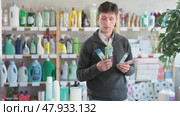 Selective middle-aged male customer choosing convenient toothbrush in large retail store. Стоковое видео, видеограф Яков Филимонов / Фотобанк Лори