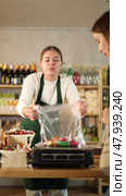 Female buyer receives advice from the seller during the weighing of sweets. Customer communicates with the seller. Стоковое видео, видеограф Яков Филимонов / Фотобанк Лори