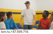 Friendly adult students chatting cheerfully while sitting in the classroom. Стоковое видео, видеограф Яков Филимонов / Фотобанк Лори