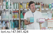 Man view trademark sign on label, chooses eco friendly panty liners. Стоковое видео, видеограф Яков Филимонов / Фотобанк Лори