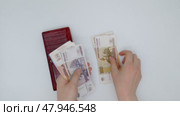 Hands take money out of the red wallet and count it, putting it on the table. Стоковое видео, видеограф Катерина Белякина / Фотобанк Лори