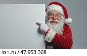 Cheerful Santa Claus Holding a Blank Sign Mock Up with Space for Your Text, Holiday Promotions and Events. Jolly Santa Claus gesturing pointing on white banner placard, festive themes advertising. Стоковое AI-видео, аниматор Марина Демидюк / Фотобанк Лори