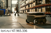 A robot is seen navigating along the warehouse floor, efficiently carrying out its programmed tasks. Стоковое AI-изображение, AI-художник Данила Большаков / Фотобанк Лори