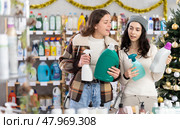Two women choose detergents and sprays at great Christmas discounts. Стоковое фото, фотограф Яков Филимонов / Фотобанк Лори