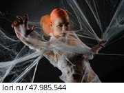 Woman entangled in a delicate net trap, showcasing beauty with vibrant red hair. Стоковое фото, фотограф Гурьянов Андрей / Фотобанк Лори