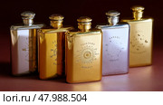 Elegant collection of engraved flasks displayed on a polished surface highlighting intricate designs and craftsmanship. Стоковое AI-изображение, AI-художник Сергей Толмачёв / Фотобанк Лори