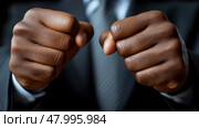 Powerful fists of a suited individual show strength and determination, highlighting a moment of focus and resolve in a business environment. Стоковое AI-изображение, AI-художник Данила Большаков / Фотобанк Лори