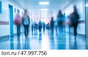 A somewhat blurry hospital corridor filled with numerous people walking about on their various errands and duties. Стоковое AI-изображение, AI-художник Anastasy Yarmolovich / Фотобанк Лори