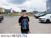 Мальчик в футболке с Huggy Wuggy и бейсболке с надписью Roblox на солнечной городской улице - Санкт-Петербург, Россия, Июнь 2023. Редакционное фото, фотограф Мария L. / Фотобанк Лори