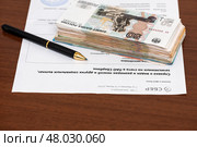 Справка о видах и размерах пенсий и других социальных выплат и стопка денег. Редакционное фото, фотограф Игорь Низов / Фотобанк Лори