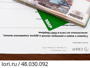 Справка о видах и размерах пенсий и других социальных выплат, пачка денег и пластиковая карточка мир. Редакционное фото, фотограф Игорь Низов / Фотобанк Лори
