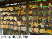 Tokyo, Japan - Sep 30 2024, Close-up view of a wall hung with wooden prayer plaques with various images and inscriptions at Gotokuji Temple, Tokyo, Japan. Редакционное фото, фотограф Сергей Богомяко / Фотобанк Лори
